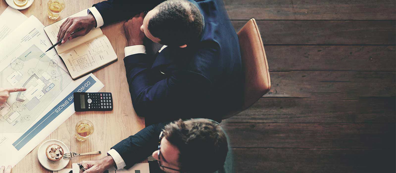 People collaborating over plans around a work table